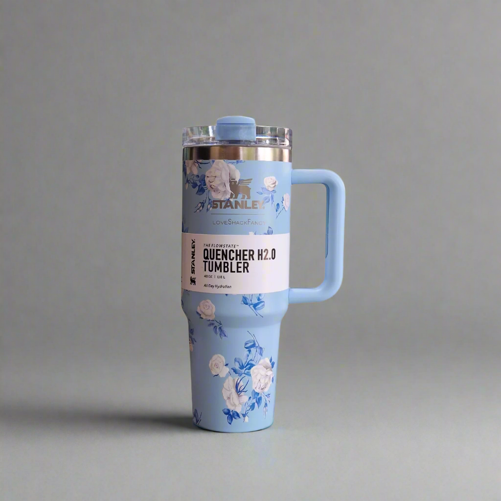 Blue tumbler with floral design on a white background